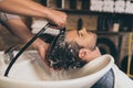 Cropped view hairstylist washing clients hair in barber Royalty Free Stock Photo