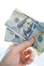 Cropped view of the hand of a man holding a fanned fistful of 100 dollar bills isolated on a white sun background Royalty Free Stock Photo