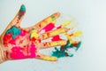 Cropped view of hand with multi-colored Holi powder, blurred background. Bright colors of Holi in the palm, close-up. Concept of Royalty Free Stock Photo