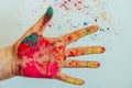 Cropped view of hand with multi-colored Holi powder, blurred background. Bright colors of Holi in the palm, close-up. Concept of Royalty Free Stock Photo