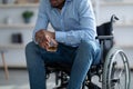 Cropped view of handicapped black guy in wheelchair drinking whiskey at home. Disability depression and alcohol overuse Royalty Free Stock Photo