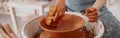 Skillful female potter creating earthen bowl on circle in workroom