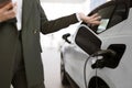 Cropped view of hands of young Caucasian saleswoman, selling electric cars. Royalty Free Stock Photo