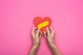 Cropped view of holding broken paper heart with patch isolated on pink background Royalty Free Stock Photo