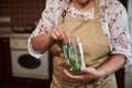 Cropped view of a housewife holding can and filling it with fresh chili pepper while pickling at home kitchen Royalty Free Stock Photo