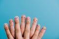 cropped view of human fingers with different emotions isolated on blue.