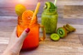 Cropped view image of female left hand holding a healthy fruit with orange juice on the table Royalty Free Stock Photo