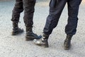 Cropped view image of the legs of municipal police men on the street patrol in high army black boots and uniform