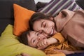 Lovely caucasian woman bonding to her son with genetic disorder while laying at the sofa Royalty Free Stock Photo