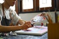 Cropped view of male artist holding messy dirty palette painting picture with brush on canvas at art studio