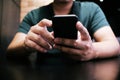 Cropped view of male hands holding cell phone with blank screen.