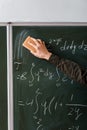Cropped view of male student wiping mathematical equations with sponge Royalty Free Stock Photo