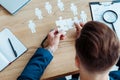 View of man holding jigsaw puzzle pieces near table Royalty Free Stock Photo