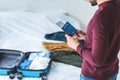 cropped view of man holding passport and ticket, suitcase with clothes Royalty Free Stock Photo