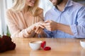 Cropped view of millennial guy holding his fiancee`s hand with diamond engagement ring at cafe Royalty Free Stock Photo