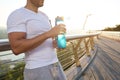 Cropped view of a muscular build European man, fit athlete with beautiful aesthetic body holding a bottle with water for Royalty Free Stock Photo