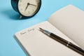 Cropped view of an open notepad with word Dear Diary, alarm clock and an ink pen isolated on blue background with copy space Royalty Free Stock Photo