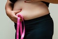 Cropped view of overweight woman measuring waist with tape measure at home, close up. Unrecognizable European woman Royalty Free Stock Photo