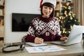 Cropped view pf woman hand with pen in Santa hat making notes on paper document