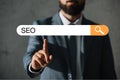 cropped view of professional developer in suit touching SEO