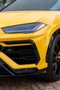 Cropped view of radiator grille and headlight on front bumper of yellow stylish car. Modern ventilation and cooling Royalty Free Stock Photo