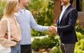 Cropped view of real estate broker shaking hands with his clients, closing house rental deal outdoors Royalty Free Stock Photo