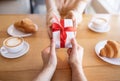 Cropped view of romantic lady and her boyfriend with gift at coffee shop, celebrating Valentine`s Day Royalty Free Stock Photo