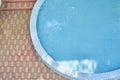 Cropped view of a round outdoor swimming pool with blue mosaic ceramic tiles, with blue water and sunny light on water Royalty Free Stock Photo