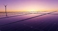 Cropped view showing the abstract pattern of clean solar panel edges intensely reflecting a dramatic purple and gold sunset over a Royalty Free Stock Photo
