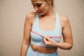 Cropped view of slim woman measuring breasts with tape measure at home, close up. A European woman checks the result of Royalty Free Stock Photo