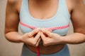 Cropped view of slim woman measuring breasts with tape measure at home, close up. Unrecognizable European woman checks Royalty Free Stock Photo