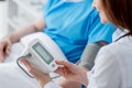 cropped view of smiling doctor measuring blood pressure of patient in hospital. Royalty Free Stock Photo