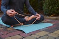 Cropped view of active male yogi sitting in lotus position, meditating with rosary, practicing yoga outdoors at sunset Royalty Free Stock Photo