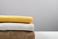 Cropped view of stack of folded colorful clothes on gray surface, side view, space for text Royalty Free Stock Photo