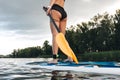 cropped view of tattooed girl standing on paddle board