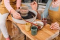 cropped view of teacher and kid painting ceramic pot with brushes Royalty Free Stock Photo