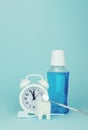 Cropped view toothbrush, white tooth model, dentist mouth mirror, white analog alarm clock and Pouring Bottle Of Mouthwash on blue Royalty Free Stock Photo