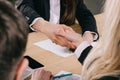 Cropped view of two businesswomen shaking hands at table in office Royalty Free Stock Photo