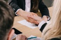 Cropped view of two businesswomen shaking hands at table Royalty Free Stock Photo