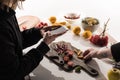 Cropped view of two photographers making food composition for commercial photography on smartphone on wooden table Royalty Free Stock Photo