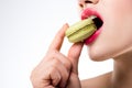 cropped view of woman biting green macaron Royalty Free Stock Photo