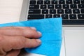 Cropped view of woman cleaning screen of laptop with napkin near notebooks on blurred background on table Royalty Free Stock Photo