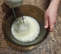 Woman confectioner mixing bizet for cake in bowl