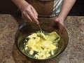 Confectioner mixing water with butter in bowl