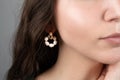 Cropped view of woman demonstrating stylish earrings with pearls. Fashionable jewelry.