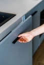 Cropped view of woman hand opening blue wooden cabinet door in modern kitchen Royalty Free Stock Photo