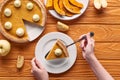 Cropped view of woman holding spatula with piece of pumpkin pie with whipped cream near baked pumpkin, cut and whole Royalty Free Stock Photo