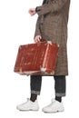 Cropped view of woman in plaid coat holding vintage weathered suitcase and checking time isolated on white. Royalty Free Stock Photo