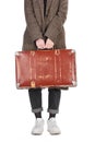 Cropped view of woman in plaid coat holding vintage weathered suitcase isolated on white. Royalty Free Stock Photo