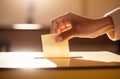 Cropped view of a woman s hand putting her vote in the ballot box. Elections and voting day. Royalty Free Stock Photo